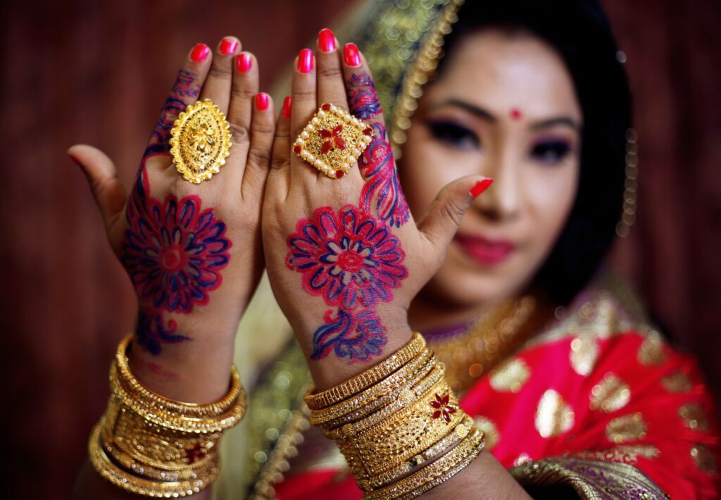 Close-up of a bride showing intricate henna and gold jewelry, symbolizing culture and tradition.
